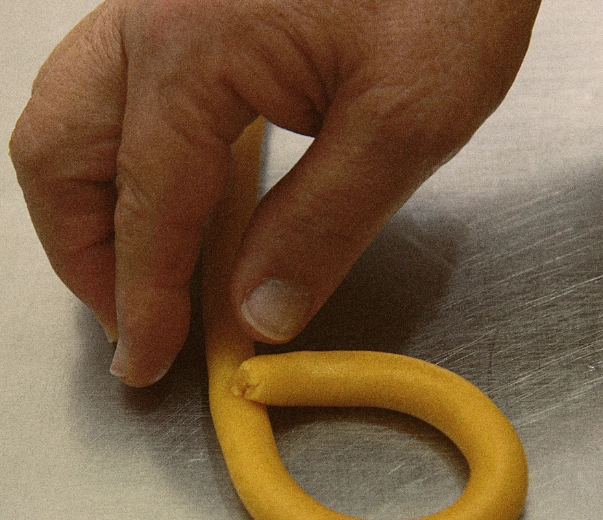 Mãos a preparar cuidadosamente a doçaria artesanal